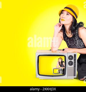 Foto von einem schönen Vogue Mädchen fällt eine Pose auf einem in Fernseher Vintage 50er Jahre Mode-Stil auf gelbem Hintergrund Stockfoto