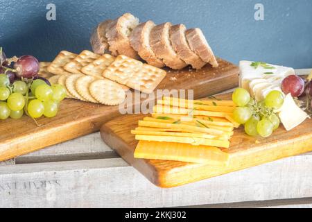 Ein Höhepunkt eines köstlichen, appetitlichen Frühstücks mit verschiedenen Käsesorten, Crackern, Brot und Trauben Stockfoto