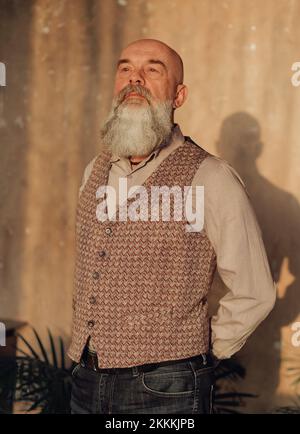 Ein selbstbewusster Mann mit Bart stand im Zimmer. Stockfoto