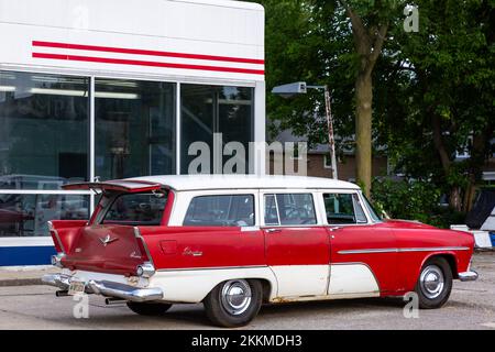 Ein antiker rot-weißer 1956 Plymouth Custom Suburban Kombi parkt vor einer Tankstelle in Auburn, Indiana, USA. Stockfoto