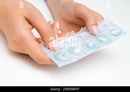 Nahaufnahme Frauen Hände halten Kontaktlinsen in den Händen auf weißem Hintergrund. Stockfoto