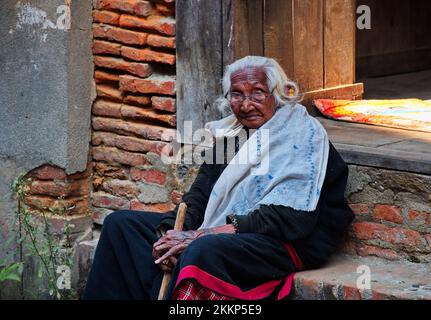 Porträt einer hochrangigen Nepali-Frau, die an der Schwelle in Kathmandu, Nepal sitzt Stockfoto
