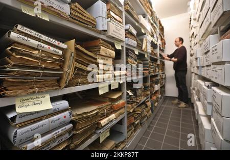 PRODUKTION – 24. November 2022, Mecklenburg-Vorpommern, Güstrow: Ein Mitarbeiter des kommunalen Archivs Güstrow steht vor einem Aktenschrank. Die Archive in Mecklenburg-Vorpommern sehen sich aufgrund des Ablaufs der Aufbewahrungsfristen in der Verwaltung einer Menge Arbeit in Form von neuem Material gegenüber. (Dpa „Welle neuer Dokumente rollt zu Archiven im Nordosten“) Foto: Danny Gohlke/dpa Stockfoto