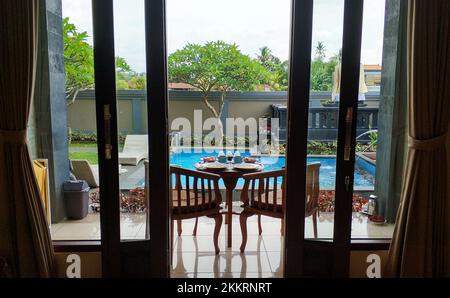 Frühstück auf einem Holztisch auf der Veranda am Pool auf der Insel Bali. Stockfoto