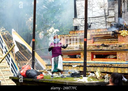 Einäscherungszeremonie für ein Mitglied der Familie Korolev auf der Insel Bali. Arbeiter, die den Altar nach der Einäscherung löschen. Bali, Indonesien - 03,02. Stockfoto