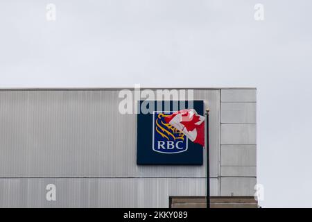 Die kanadische Flagge fliegt vor dem RBC-Logo der Royal Bank of Canada auf der Seite eines Bürogebäudes in Ottawa, Kanadas Hauptstadt. Stockfoto