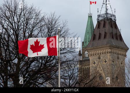 Die kanadische Flagge fliegt voll vor dem Parlament von Kanada, der Friedensturm ist im Hintergrund an einem bewölkten Tag in Ottawa zu sehen. Stockfoto