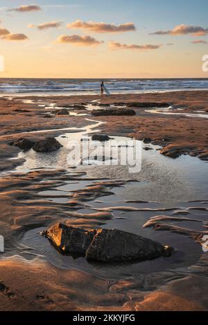 Schönes Landschaftsbild im Sommer bei Sonnenuntergang von Widemouth Bay in Devon England mit goldenem Stundenlicht am Strand Stockfoto