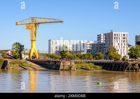 Der gelbe Titankran, ein historisches Denkmal, das 1954 in den Werften auf der Insel Nantes, Frankreich, erbaut wurde, mit modernen Gebäuden im Hintergrund. Stockfoto