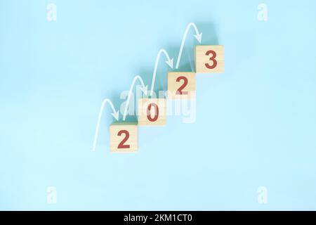 Erfolgsleiter für das neue Jahr 2023, positive Aussichten und Konzept für schrittweises oder schrittweises Wachstum. Holzblöcke mit blauem Hintergrund. Stockfoto