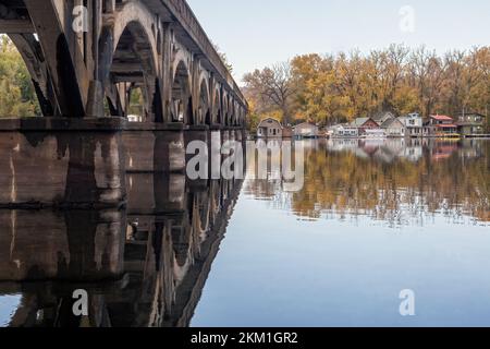 SideView der Latsch Island Bridge über dem Mississippi River mit Hausbooten auf der gegenüberliegenden Uferseite des Flusses in Winona, Minnesota, USA. Stockfoto