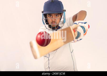 Porträt eines Jungen, der während eines Cricket-Spiels einen Schuss schießt Stockfoto