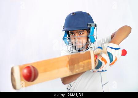 Porträt eines Jungen, der während eines Cricket-Spiels einen Schuss schießt Stockfoto