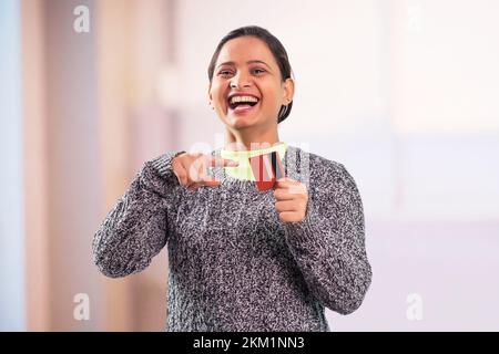 Porträt einer glücklichen jungen Frau, die Kreditkarte zeigt Stockfoto