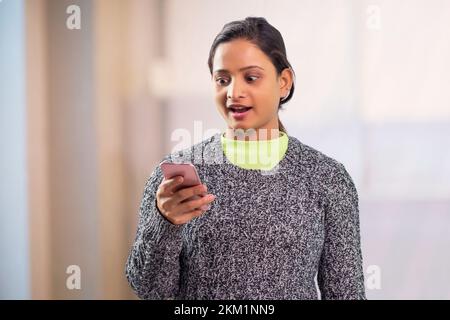 Junge indische Frauen, die ein Smartphone benutzen Stockfoto