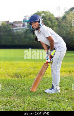 Weibliche Cricketspieler üben im Boden Stockfoto