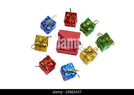 Rote Geschenkbox mit roter Schleife mit goldenem Rand am Deckel, für Ring oder Schmuck, umgeben von kleinen bunten Geschenken mit goldenem Garn. Draufsicht Stockfoto