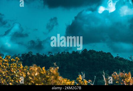 Schöne türkisfarbene Himmelslandschaft mit weißen Wolken über den Bergen am Morgen Stockfoto