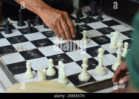 Schachbrett und Hände, Schachspiele, die der Gesellschaft im Allgemeinen vertraut sind Stockfoto