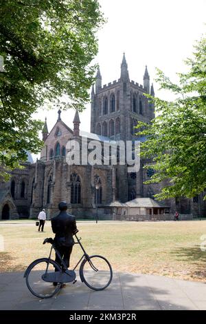 Statue von Sir Edward Elgar, der sich vor der Kathedrale Hereford, Herefordshire, auf einem Fahrrad lehnt Stockfoto