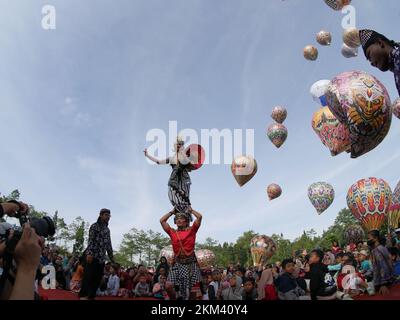 Lengger Tänzer aus Wonosobo Regency, Zentraljava, Indonesien tanzen vor dem Hintergrund von Heißluftballons Stockfoto