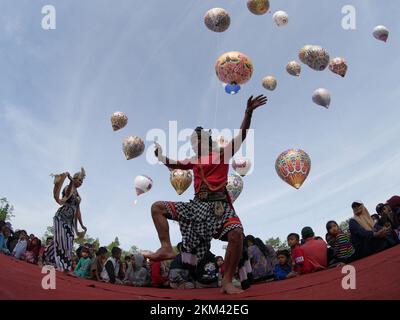 Lengger Tänzer aus Wonosobo Regency, Zentraljava, Indonesien tanzen vor dem Hintergrund von Heißluftballons Stockfoto