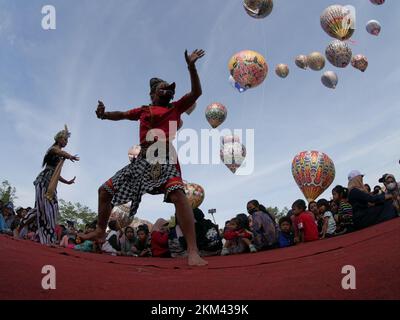 Lengger Tänzer aus Wonosobo Regency, Zentraljava, Indonesien tanzen vor dem Hintergrund von Heißluftballons Stockfoto