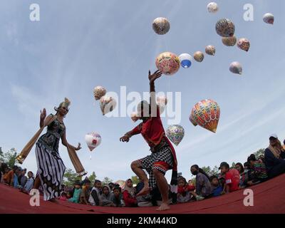 Lengger Tänzer aus Wonosobo Regency, Zentraljava, Indonesien tanzen vor dem Hintergrund von Heißluftballons Stockfoto