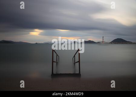 Alte verlassene Holzfischerpier am Meer auf dem Land. Küstenstadt Turgutreis und spektakulärer Sonnenschein. Langzeitbelichtung. Ruhe Stockfoto