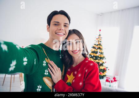 Selfie Nahaufnahme Foto Porträt von jungen Paar Aufnahme umarmt Wintersaison Ferien Chillen Zuhause Urlaub Toilette in der Nähe Weihnachten Baumbeleuchtung Dekor innen Stockfoto