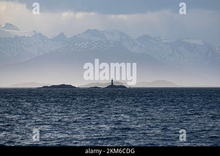 Die Andres-Berge im Hintergrund mit der Silhouette des Leuchtturms Les Eclaireurs. Blick vom hinteren Ende des Bootes vom Ozean Stockfoto