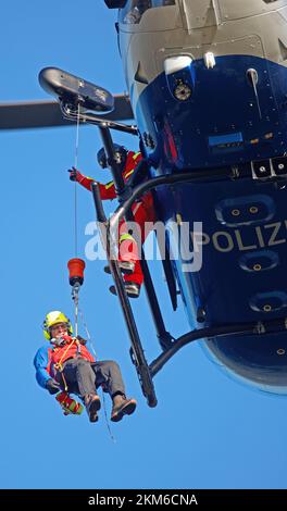 Ballenstedt, Deutschland. 26.. November 2022. Ein Polizeihubschrauber bringt ein Mitglied des Harzer Bergrettungsteams mit einer Winde über dem Bergmassiv auf dem Gegensteinen. Die 20 Mitglieder der Bergwacht, die in der Luftrettung ausgebildet sind, müssen ihre theoretischen Kenntnisse regelmäßig in die Praxis umsetzen. Insgesamt ist dies der vierte Übungstag mit der Polizei. Kredit: Matthias Bein/dpa/Alamy Live News Stockfoto