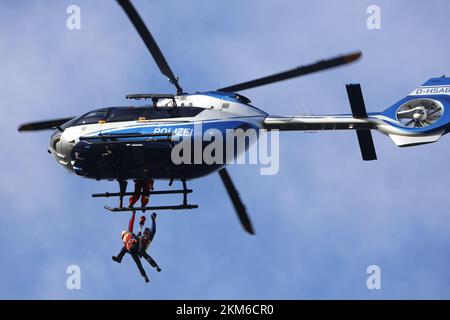 Ballenstedt, Deutschland. 26.. November 2022. Ein Polizeihubschrauber bringt ein Mitglied des Harzer Bergrettungsteams mit einer Winde über dem Bergmassiv auf dem Gegensteinen. Die 20 Mitglieder der Bergwacht, die in der Luftrettung ausgebildet sind, müssen ihre theoretischen Kenntnisse regelmäßig in die Praxis umsetzen. Insgesamt ist dies der vierte Übungstag mit der Polizei. Kredit: Matthias Bein/dpa/Alamy Live News Stockfoto