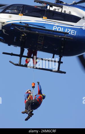 Ballenstedt, Deutschland. 26.. November 2022. Ein Polizeihubschrauber bringt ein Mitglied des Harzer Bergrettungsteams mit einer Winde über dem Bergmassiv auf dem Gegensteinen. Die 20 Mitglieder der Bergwacht, die in der Luftrettung ausgebildet sind, müssen ihre theoretischen Kenntnisse regelmäßig in die Praxis umsetzen. Insgesamt ist dies der vierte Übungstag mit der Polizei. Kredit: Matthias Bein/dpa/Alamy Live News Stockfoto