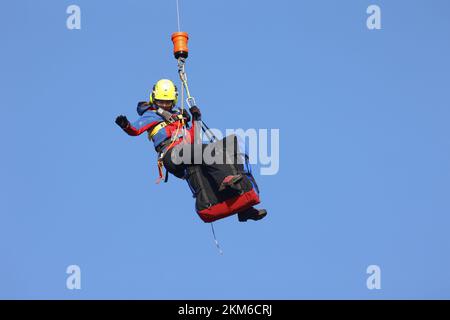 Ballenstedt, Deutschland. 26.. November 2022. Ein Polizeihubschrauber bringt ein Mitglied des Harzer Bergrettungsteams mit einer Winde über dem Bergmassiv auf dem Gegensteinen. Die 20 Mitglieder der Bergwacht, die in der Luftrettung ausgebildet sind, müssen ihre theoretischen Kenntnisse regelmäßig in die Praxis umsetzen. Insgesamt ist dies der vierte Übungstag mit der Polizei. Kredit: Matthias Bein/dpa/Alamy Live News Stockfoto