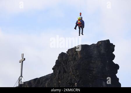 Ballenstedt, Deutschland. 26.. November 2022. Ein Polizeihubschrauber bringt ein Mitglied des Harzer Bergrettungsteams mit einer Winde über dem Bergmassiv auf dem Gegensteinen. Die 20 Mitglieder der Bergwacht, die in der Luftrettung ausgebildet sind, müssen ihre theoretischen Kenntnisse regelmäßig in die Praxis umsetzen. Insgesamt ist dies der vierte Übungstag mit der Polizei. Kredit: Matthias Bein/dpa/Alamy Live News Stockfoto