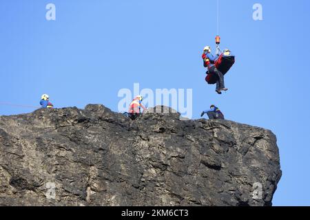 Ballenstedt, Deutschland. 26.. November 2022. Ein Polizeihubschrauber bringt ein Mitglied des Harzer Bergrettungsteams mit einer Winde über dem Bergmassiv auf dem Gegensteinen. Die 20 Mitglieder der Bergwacht, die in der Luftrettung ausgebildet sind, müssen ihre theoretischen Kenntnisse regelmäßig in die Praxis umsetzen. Insgesamt ist dies der vierte Übungstag mit der Polizei. Kredit: Matthias Bein/dpa/Alamy Live News Stockfoto