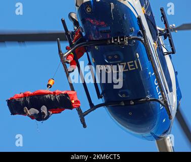 Ballenstedt, Deutschland. 26.. November 2022. Ein Polizeihubschrauber bringt ein Mitglied des Harzer Bergrettungsteams mit einer Winde über dem Bergmassiv auf dem Gegensteinen. Die 20 Mitglieder der Bergwacht, die in der Luftrettung ausgebildet sind, müssen ihre theoretischen Kenntnisse regelmäßig in die Praxis umsetzen. Insgesamt ist dies der vierte Übungstag mit der Polizei. Kredit: Matthias Bein/dpa/Alamy Live News Stockfoto