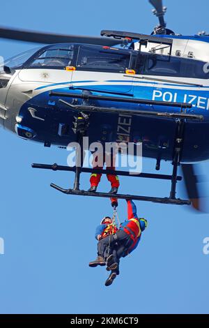 Ballenstedt, Deutschland. 26.. November 2022. Ein Polizeihubschrauber bringt ein Mitglied des Harzer Bergrettungsteams mit einer Winde über dem Bergmassiv auf dem Gegensteinen. Die 20 Mitglieder der Bergwacht, die in der Luftrettung ausgebildet sind, müssen ihre theoretischen Kenntnisse regelmäßig in die Praxis umsetzen. Insgesamt ist dies der vierte Übungstag mit der Polizei. Kredit: Matthias Bein/dpa/Alamy Live News Stockfoto