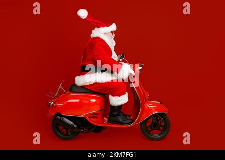 Profil Seitenansicht seiner er schön lustig dick Weißhaarige Santa Reiten Motorrad schnelle Geschwindigkeit Eile Shopping Verkauf Hut Ball fliegen isoliert Stockfoto