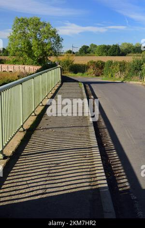 Schatten auf der Straßenbrücke über den Fluss Avon in Kellaways, Teil des Maud Heath's Causeway, die sich im Hintergrund nach links abbiegen. Stockfoto