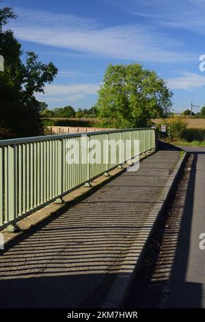 Schatten auf der Straßenbrücke über den Fluss Avon in Kellaways, Teil des Maud Heath's Causeway, die sich im Hintergrund nach links abbiegen. Stockfoto