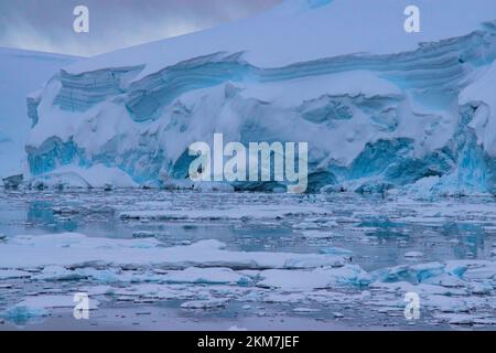 Die Eisfeild und Eisberge, die im Antarktischen Ozean fließen. Mit Schichten aus Eis und Schnee, die die Eisberge bilden. Stockfoto