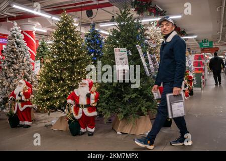 Weihnachtsmann-Figuren bewachen die Weihnachtsbäume und Dekorationen in einem Home Depot-Geschäft in Chelsea in New York am Samstag, den 19. November 2022. Nur 36 weitere Einkaufstage bis Weihnachten. (© Richard B. Levine) Stockfoto