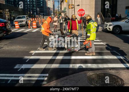 Die Arbeiter installieren neue thermoplastische Fahrbahnmarkierungen, nachdem sie am Donnerstag, den 17. November 2022, im Stadtviertel Chelsea in New York kürzlich neu gepflastert wurden. (© Richard B. Levine) Stockfoto