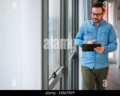 Kluger männlicher Programmierer, der seine Kollegen wegen eines Fehlers im System kontaktiert. Stockfoto