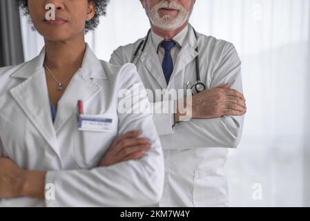 Bild von erfahrenen Ärzten, die ihre Arme kreuzen, posieren. Stockfoto