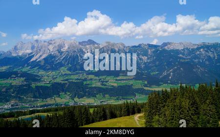 Ein Wanderweg mit Blick auf die wunderschöne Alpenlandschaft mit ausgedehntem grünen Alpental in den österreichischen Alpen der Region Schladming-Dachstein Stockfoto