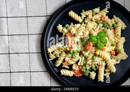 Nudelsalat mit Gemüse mit Sauce und Gewürzen. Stockfoto