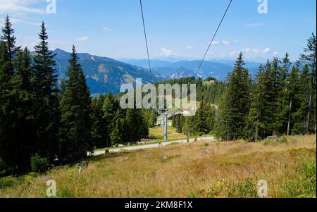 Ein Wanderweg mit Blick auf die wunderschöne Alpenlandschaft mit ausgedehntem grünen Alpental in den österreichischen Alpen der Region Schladming-Dachstein Stockfoto
